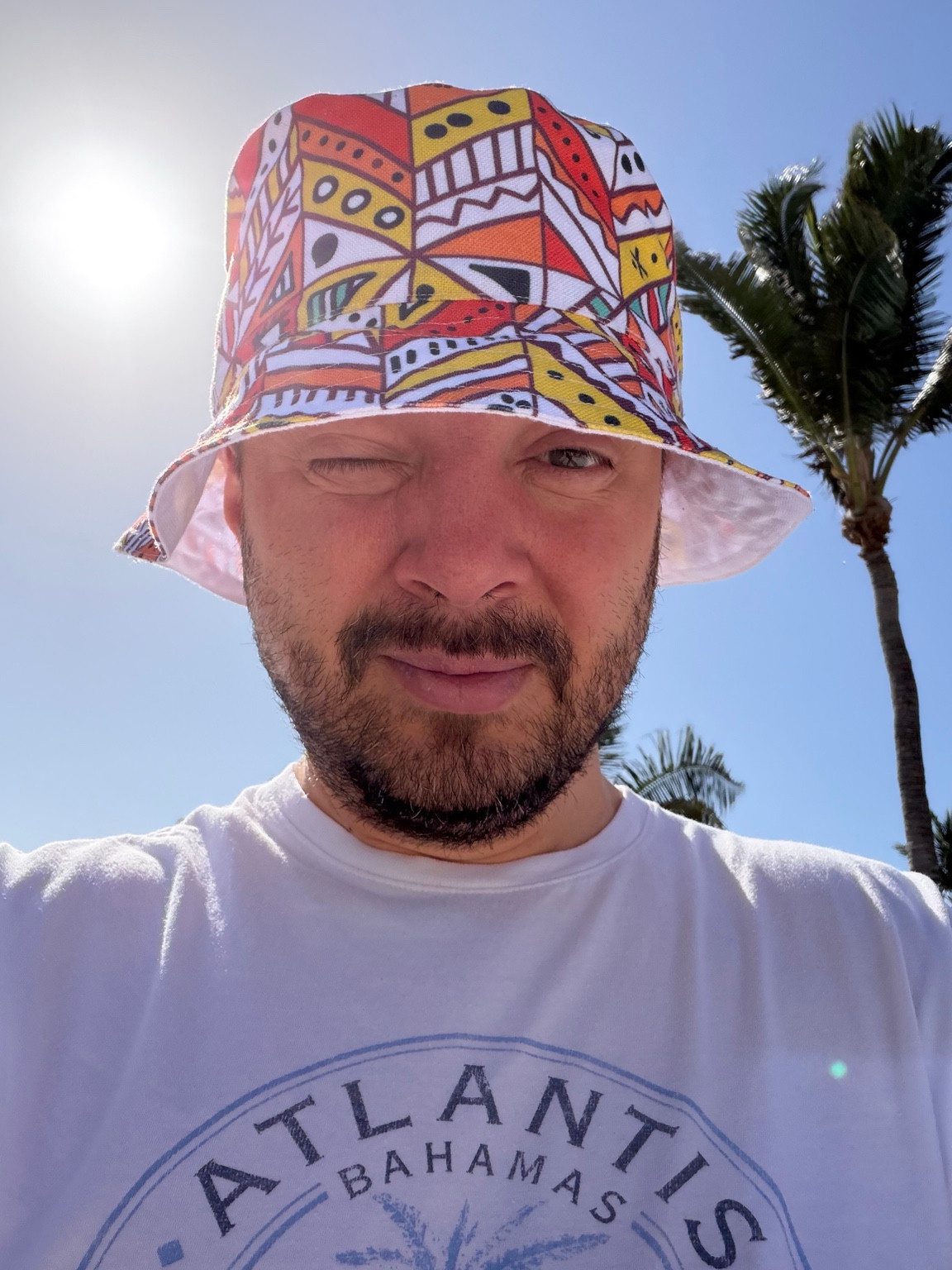 Denys outdoors in a colorful sun hat